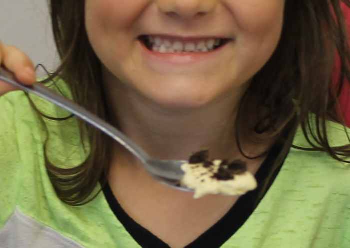 Sampling a "comet" made from ice cream and an Oreo cookie = Spoonful of ice cream (ice) dipped in crushed Oreo cookie (dirt) = coma & spoon is tail