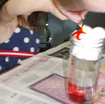 Red dye raining through a cloud of shaving cream