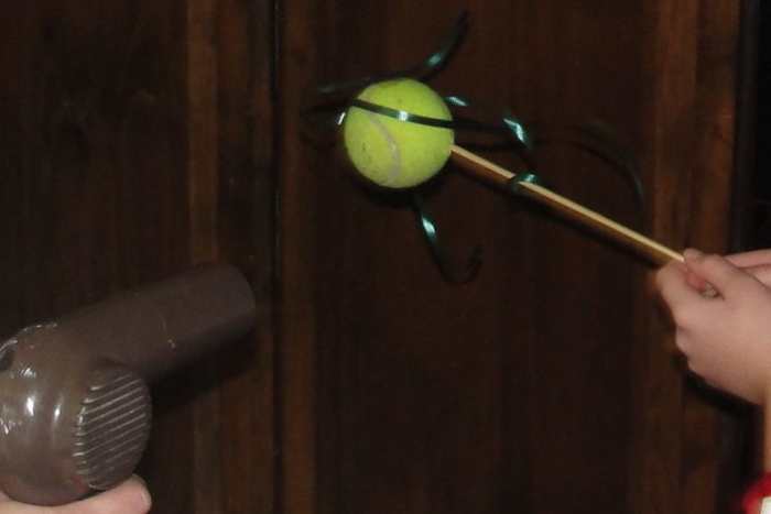 Comet on a stick made using a tennis ball and curling ribbon on a wooden skewer