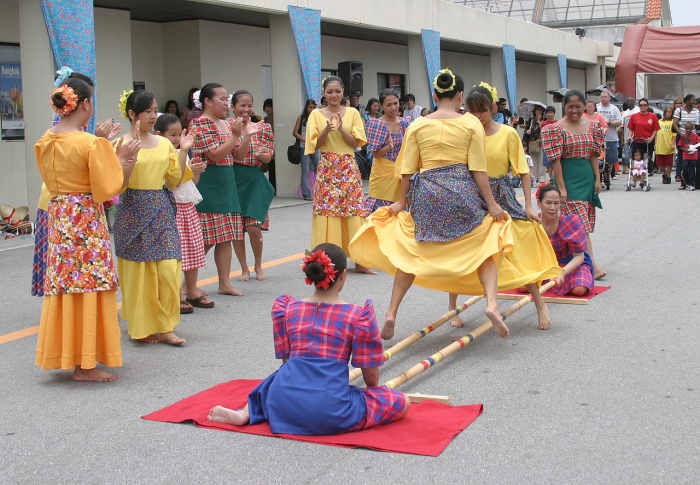 Members from the Philippine Cultural Dancers group performing the tinikling