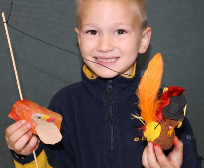 As students finish their projects, take photos of them with their Thanksgiving turkey crafts.