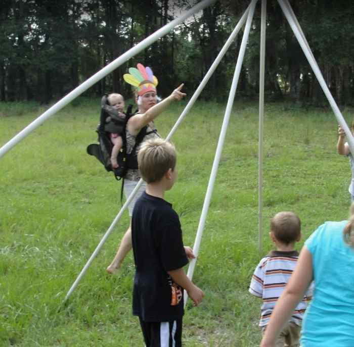 Constructing a tepee while carrying a baby using a "cradle board"