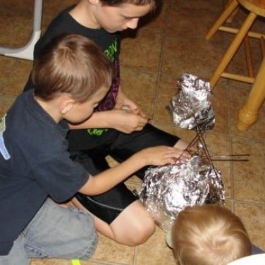 Creating a full size model of Sputnik I using a basketball, aluminum foil, metal skewers, and a recording device (to make continuous beeping noises)