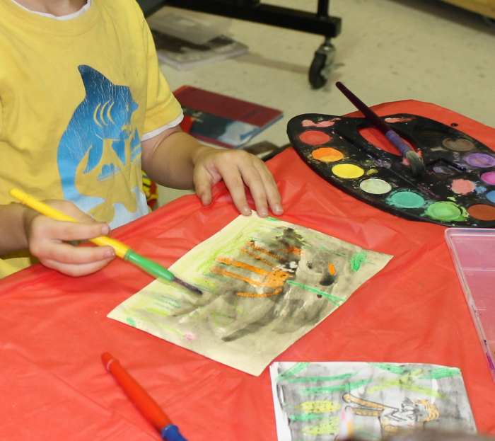 Painting black watercolor paint over the crayon drawing (water resist technique) 