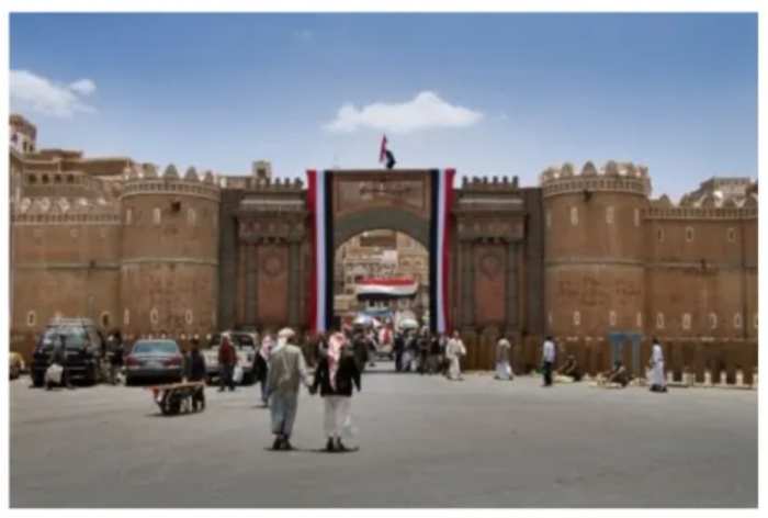 Male friends holding hands outside the wall of the Old City of Sana'a