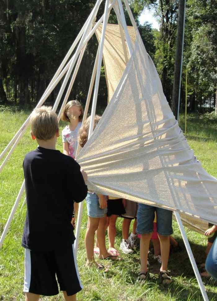 Constructing a tepee using PVC pipe, rubber bands, and a sheet