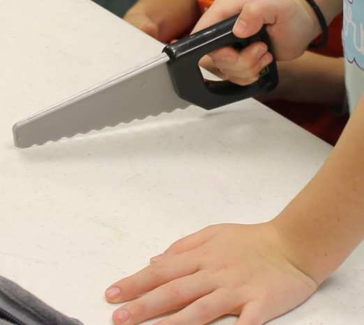 The ribosomes (with toy tools) make proteins on the endoplasmic reticulum (table).